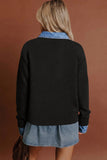 A woman shown from the back wearing a black knit sweater layered over a light blue denim shirt and denim skirt, against a solid warm brown background.