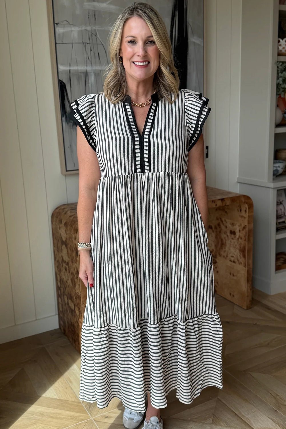 Woman wearing a black and white striped dress indoors.
