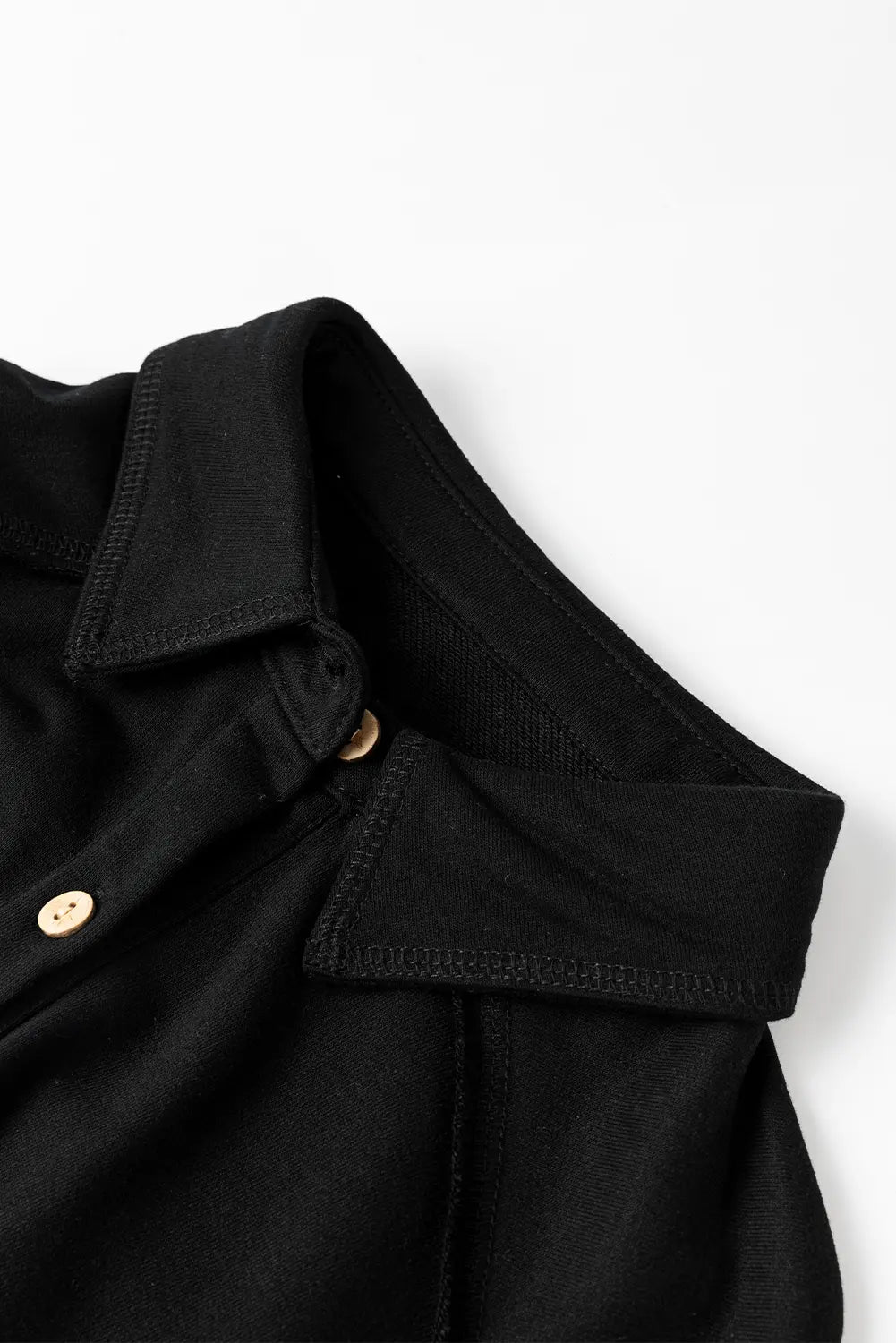 Close-up of a black polo shirt collar on a white background