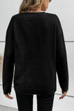 Person wearing a black sweater against a white wall