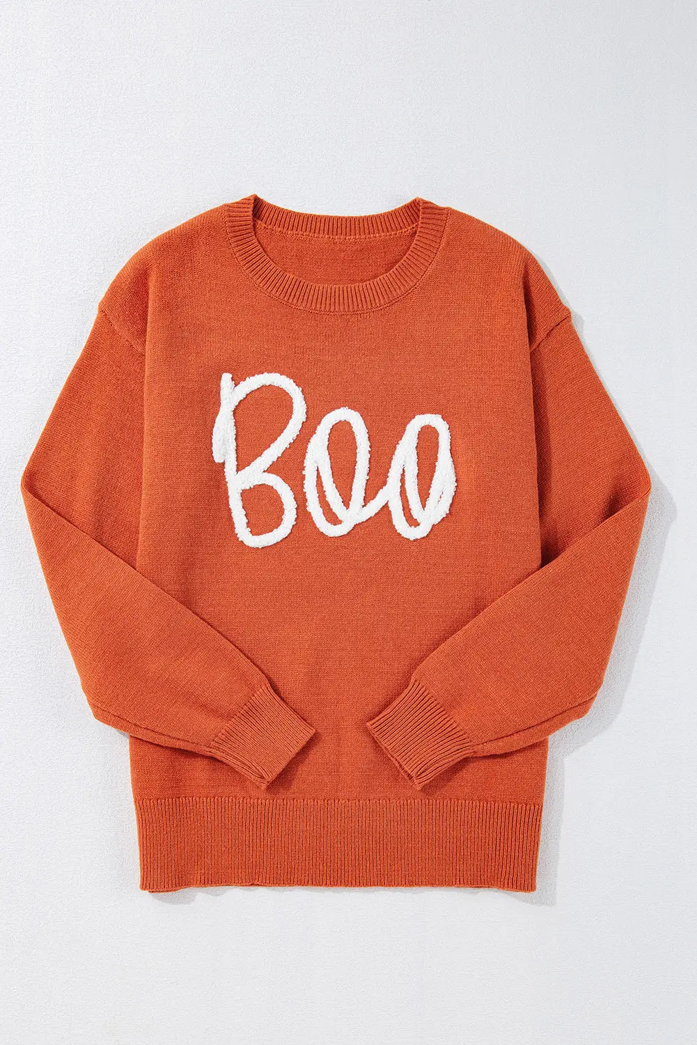 Orange crewneck sweater with white cursive “Boo” text, laid flat.