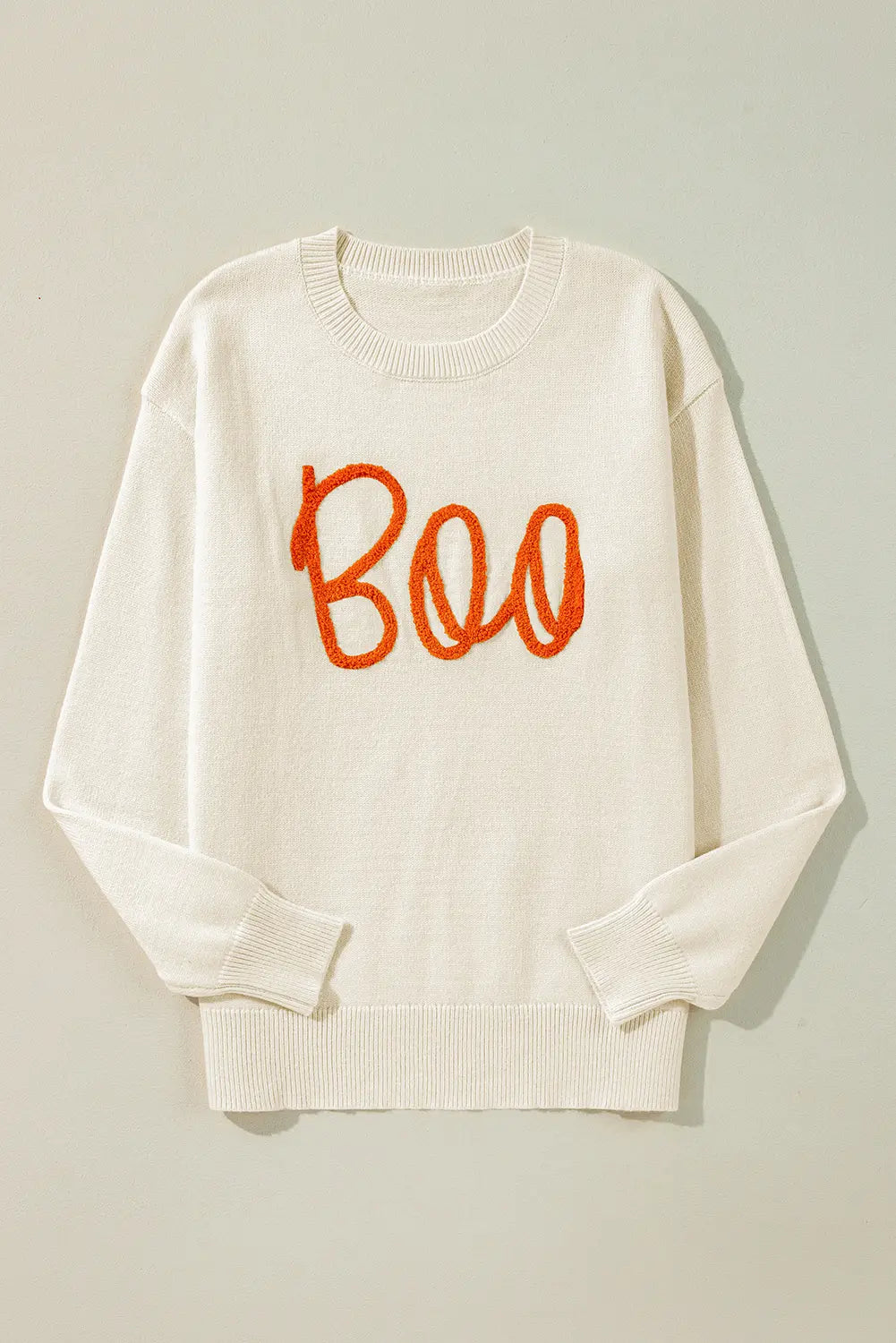 Off-white crewneck sweater with orange “Boo” embroidery, laid flat.
