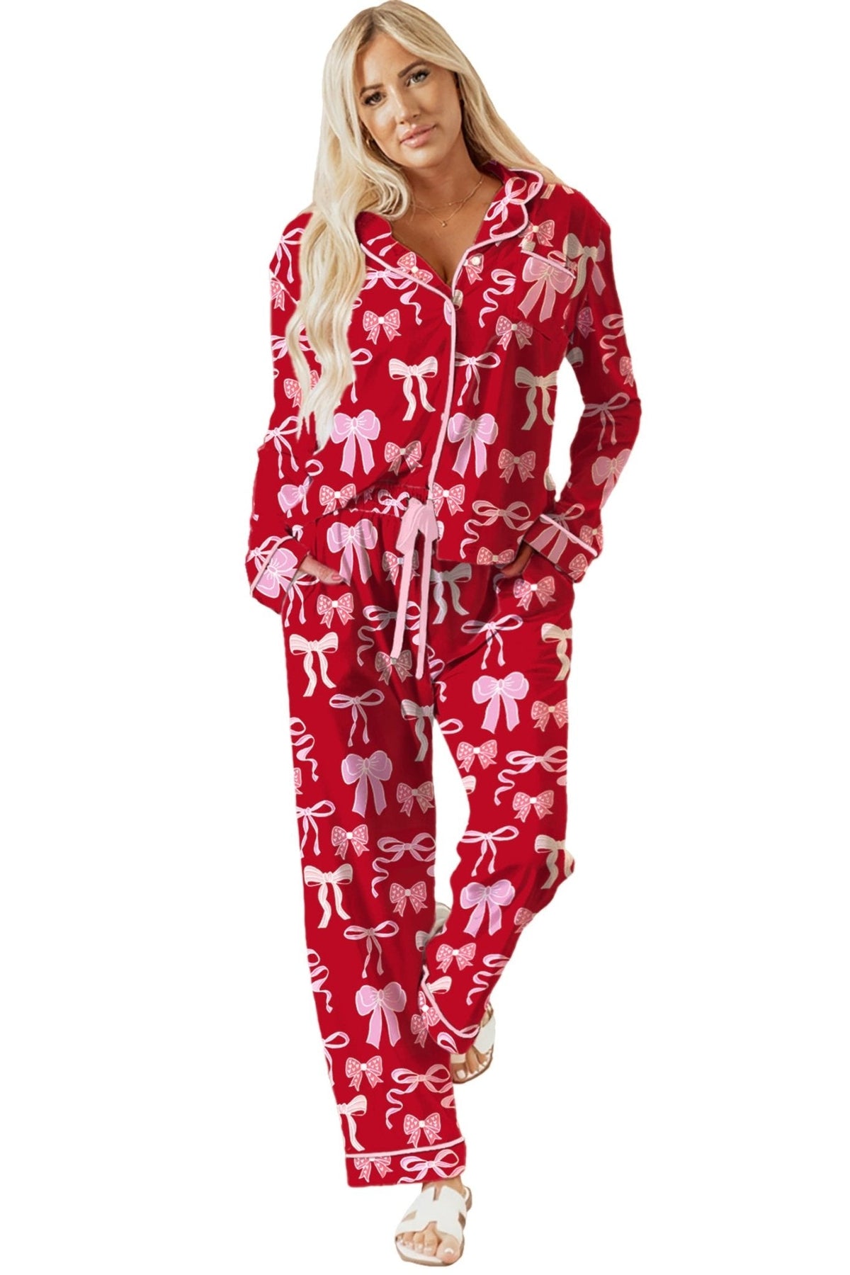 Woman wearing a red pajama set with white bows on a white background