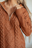 Close-up of rust-orange cable-knit zip-up sweater with textured pattern, ribbed collar, and zipper.