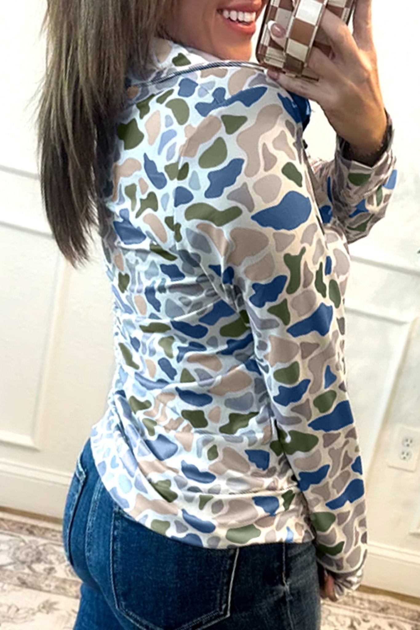 Person wearing a camouflage-patterned shirt taking a selfie.