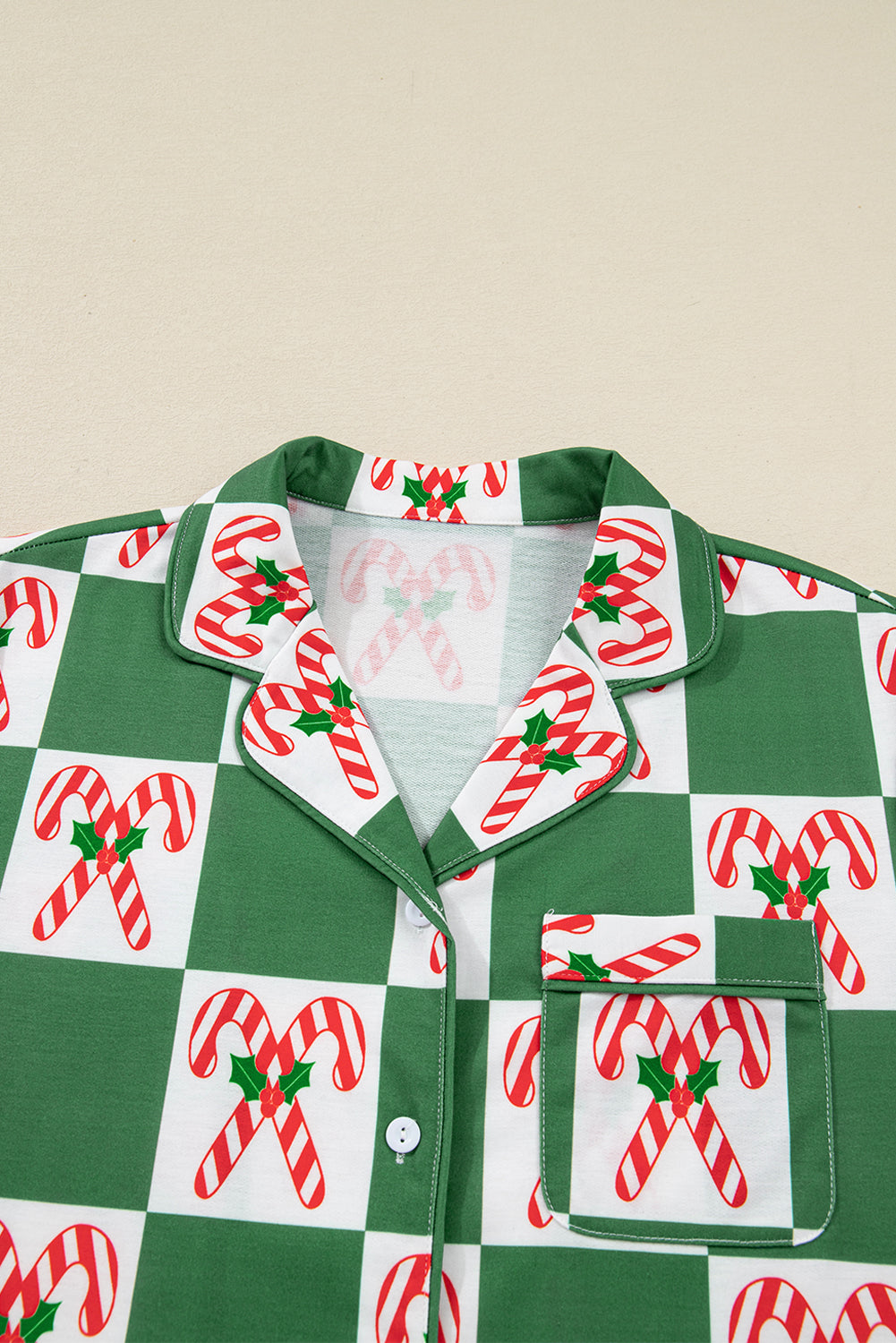 Green pajama top with candy cane pattern on a beige background
