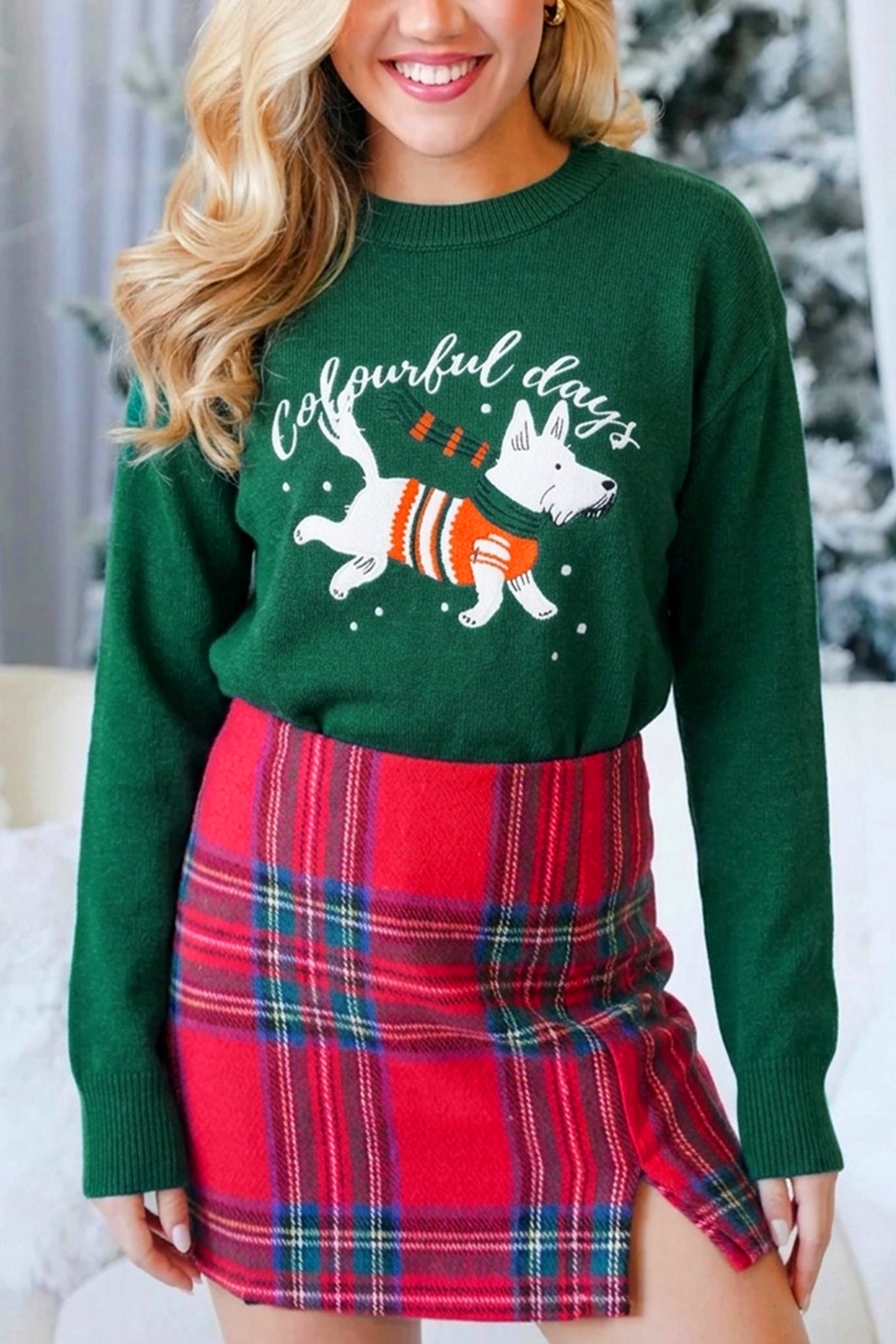 Woman in dark green “colourful days” dog-print sweater with red-green plaid mini skirt.