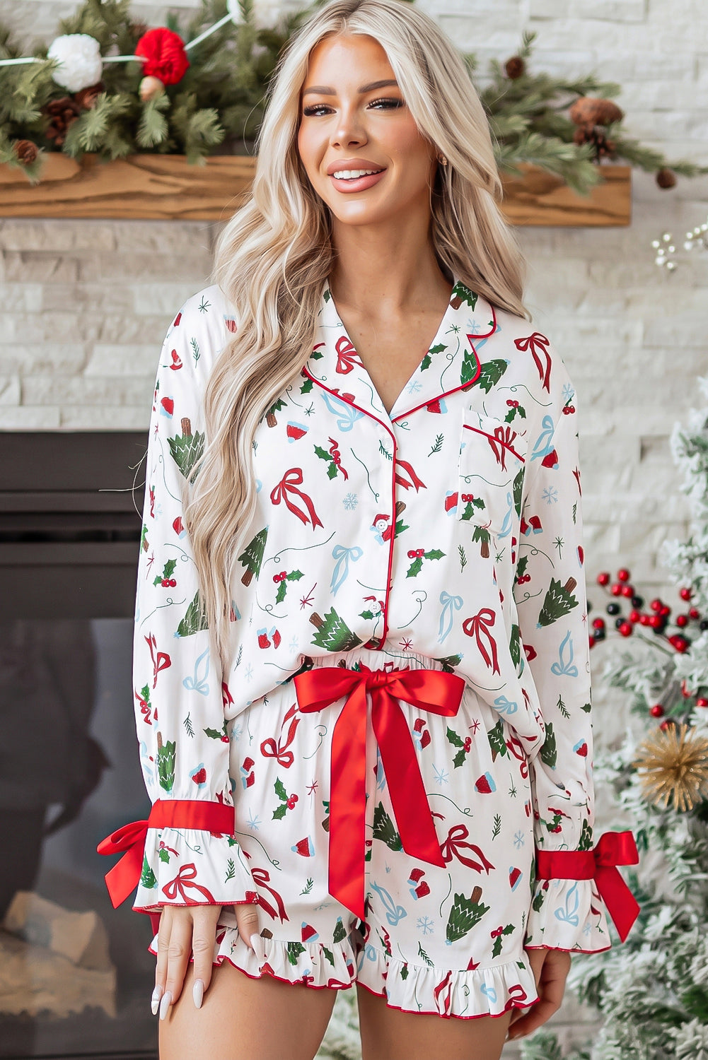 Woman in white Christmas-print pajamas with red tie and bow cuffs.
