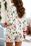 Woman from behind in off-white Christmas pajamas with trees, bows, and candy canes.