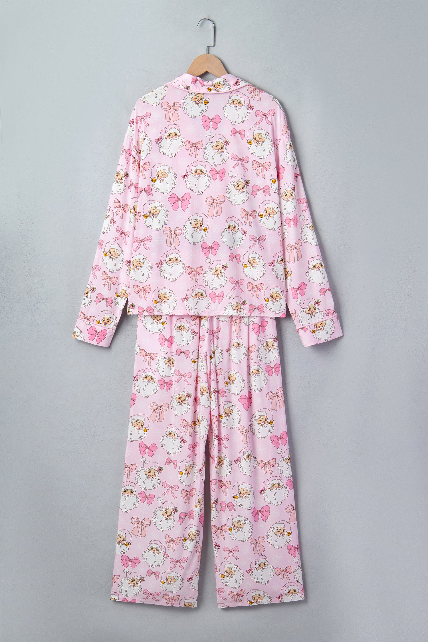 Pink long-sleeve pajama set with all-over cartoon cat print on hanger.
