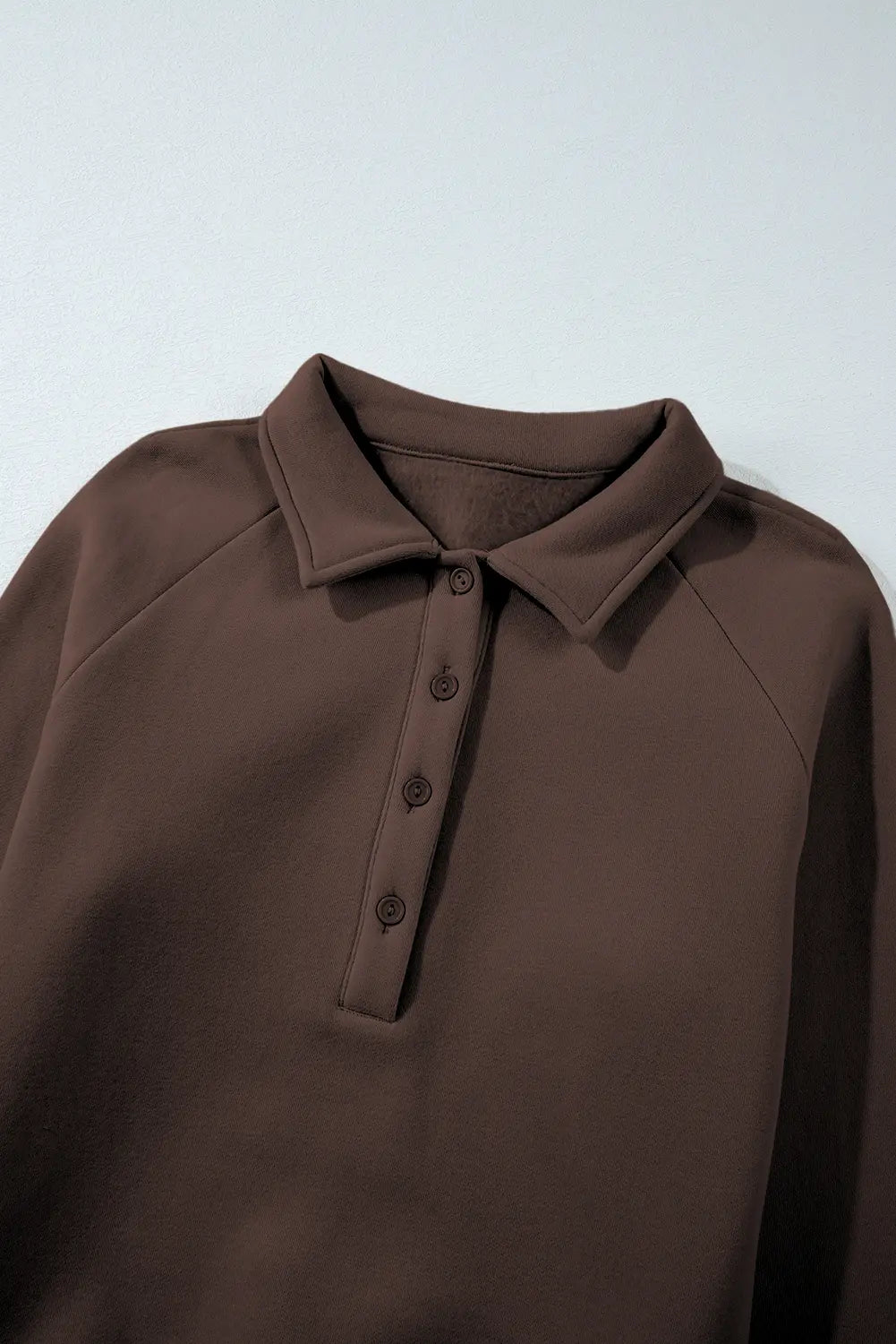 Brown polo shirt on a light gray background
