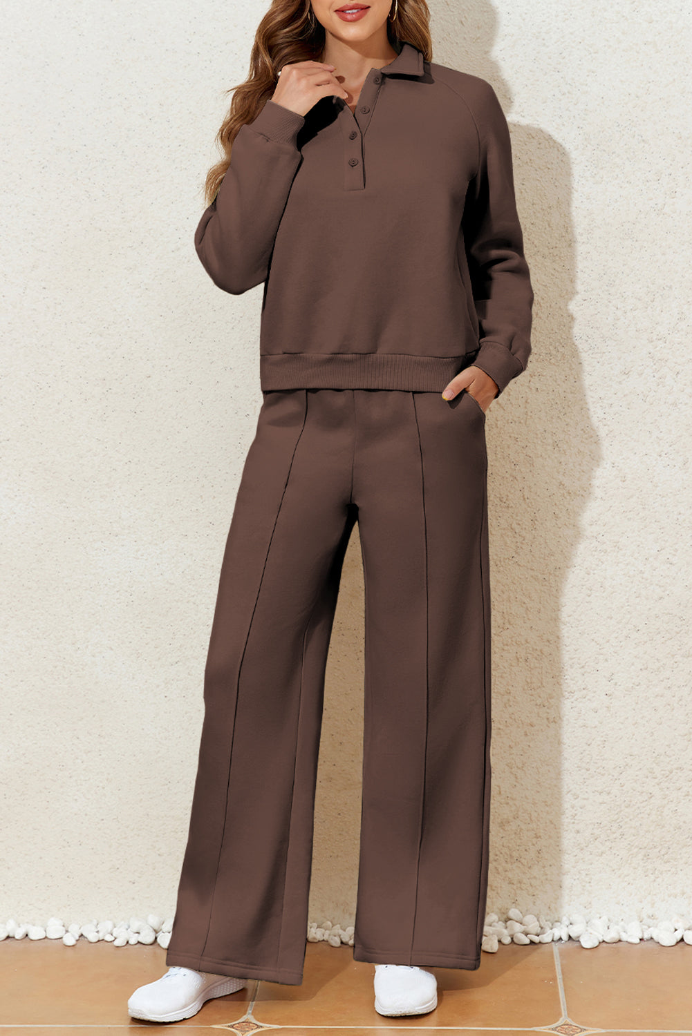 Woman wearing a brown outfit with a matching top and wide-leg pants.