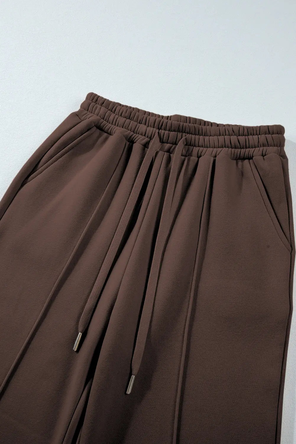 Brown pants with drawstring on a light gray background