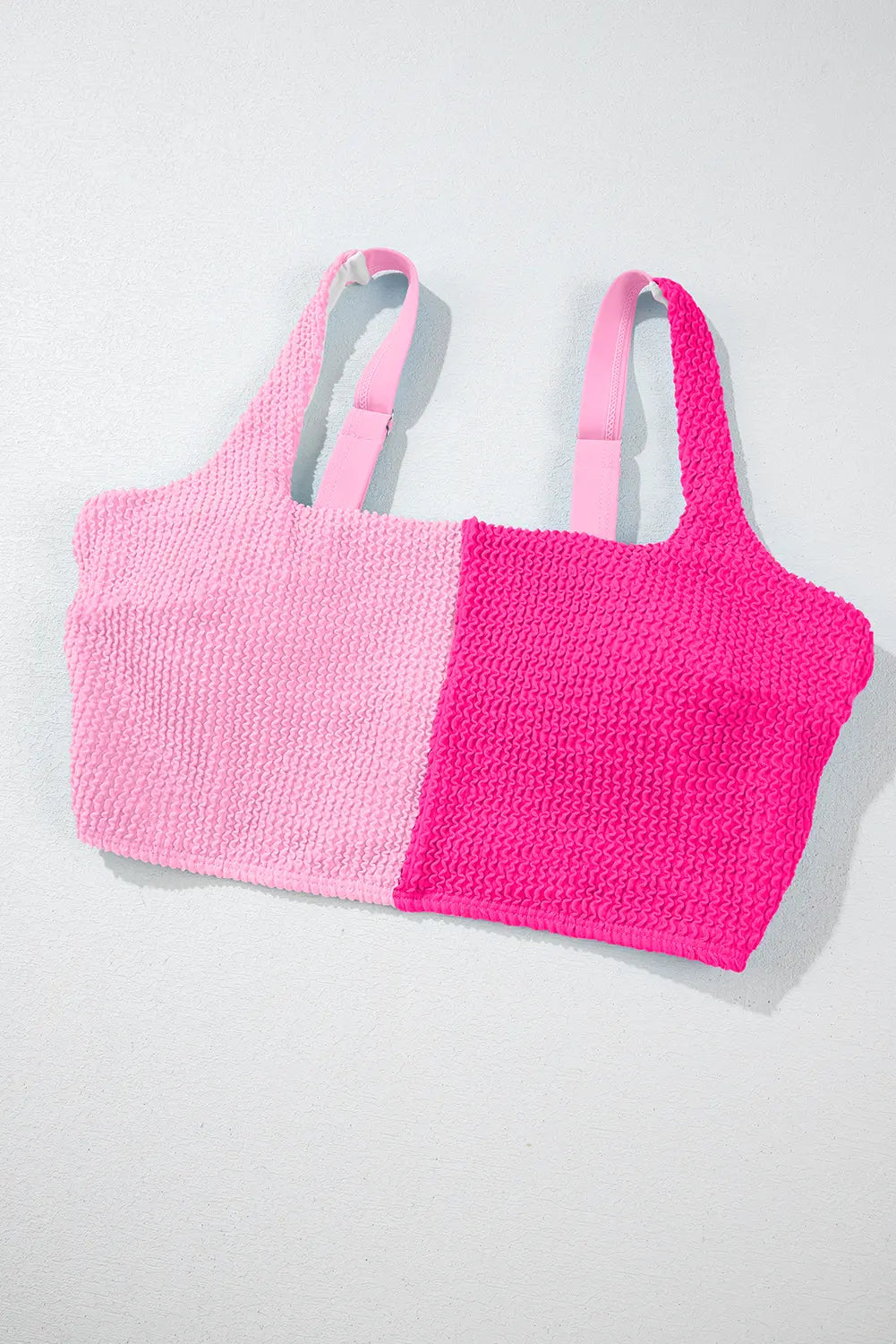 Two pink crochet tops on a light gray background