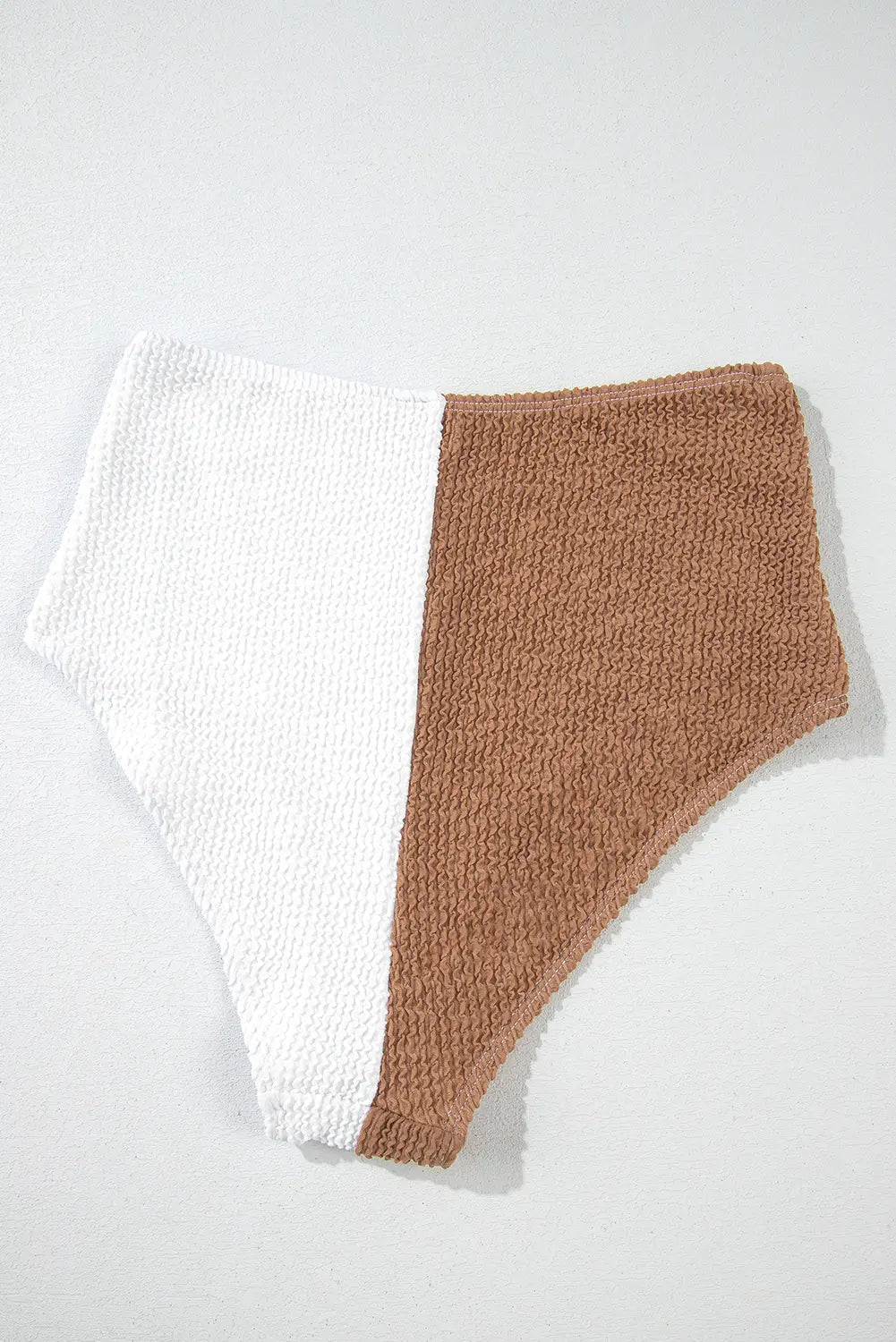 Two-tone knitted shorts with white and brown sections on a light gray background