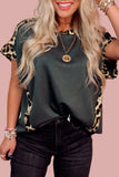 Woman wearing a dark green top with leopard print sleeves against a pink background