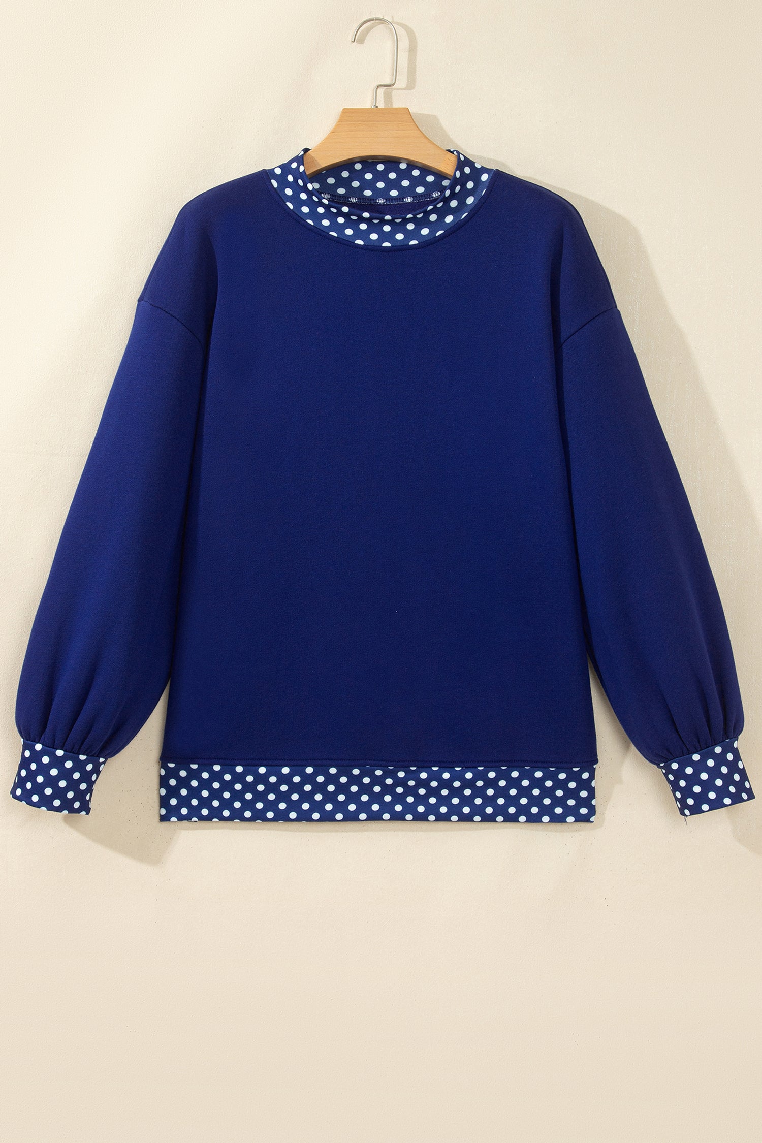 Royal blue sweatshirt with white polka-dot trim on mock neck, cuffs, and hem.