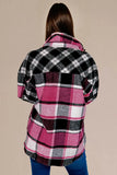 Person wearing a pink and black plaid shirt against a beige background
