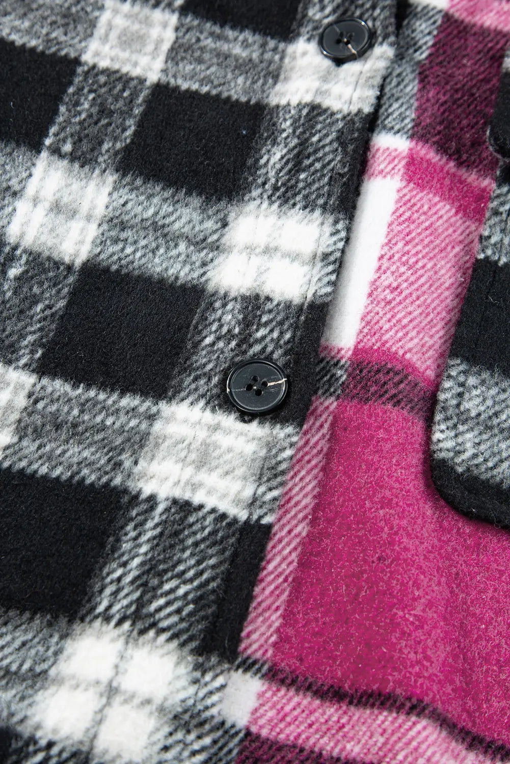 Close-up of a plaid fabric with black, white, and pink colors.