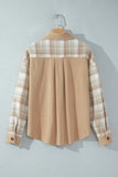 A long-sleeve collared shirt hanging on a wooden hanger against a light gray wall. The back of the shirt is solid tan, while the shoulders and sleeves feature a beige and white plaid pattern.