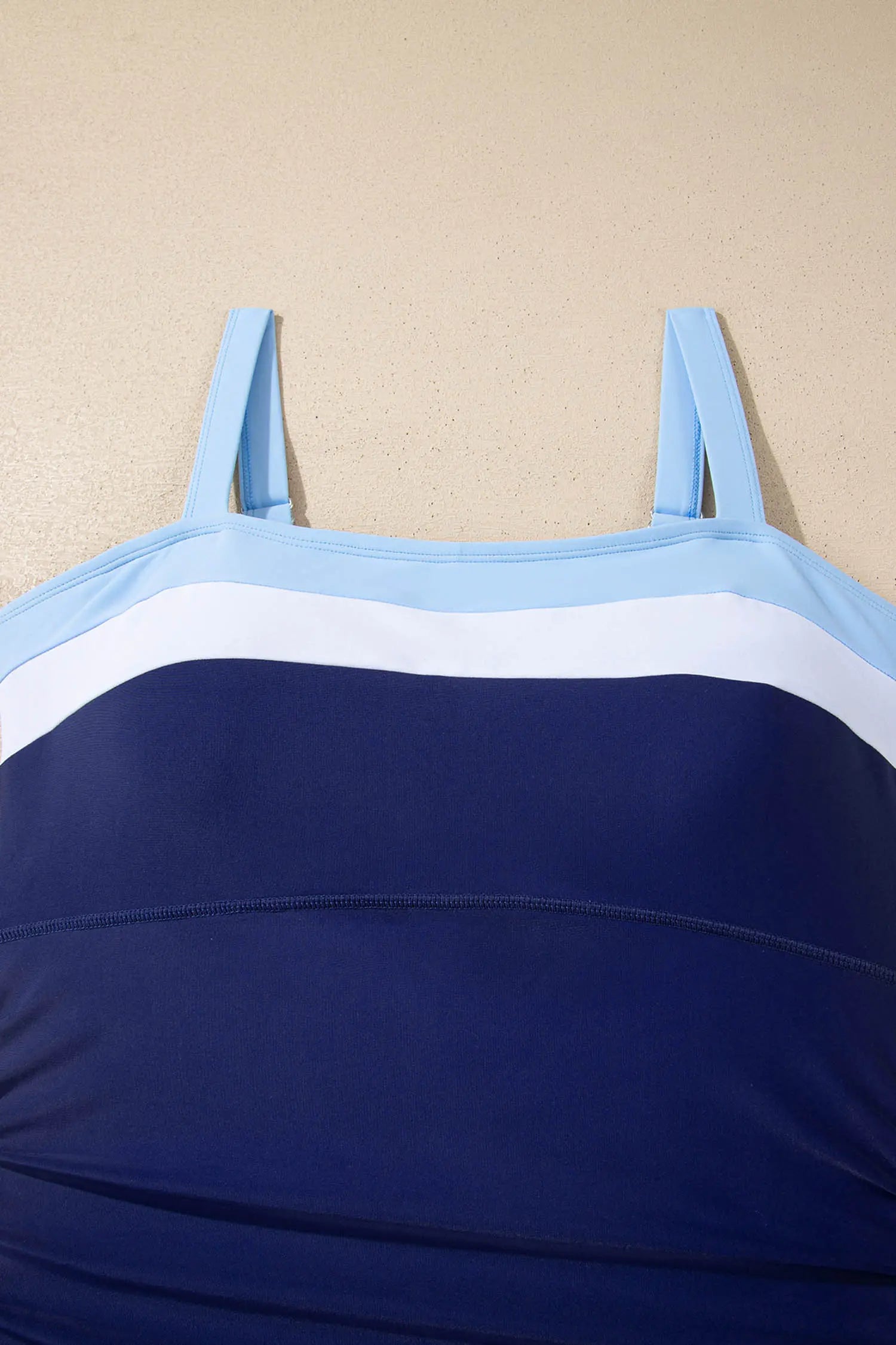 Blue and white striped top on a beige background