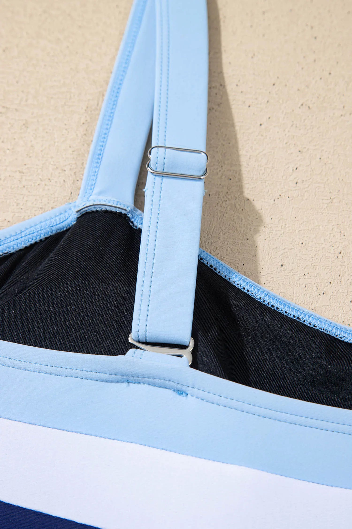 Close-up of a black and blue bag with a strap on a beige background