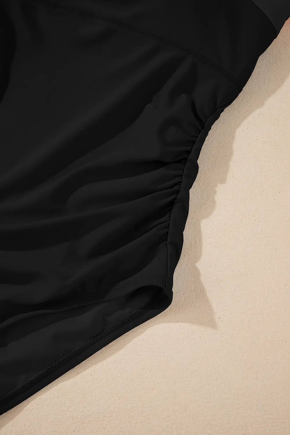 Black fitted sheet on a beige bed