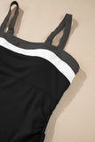 Black swimsuit with white trim on a beige surface