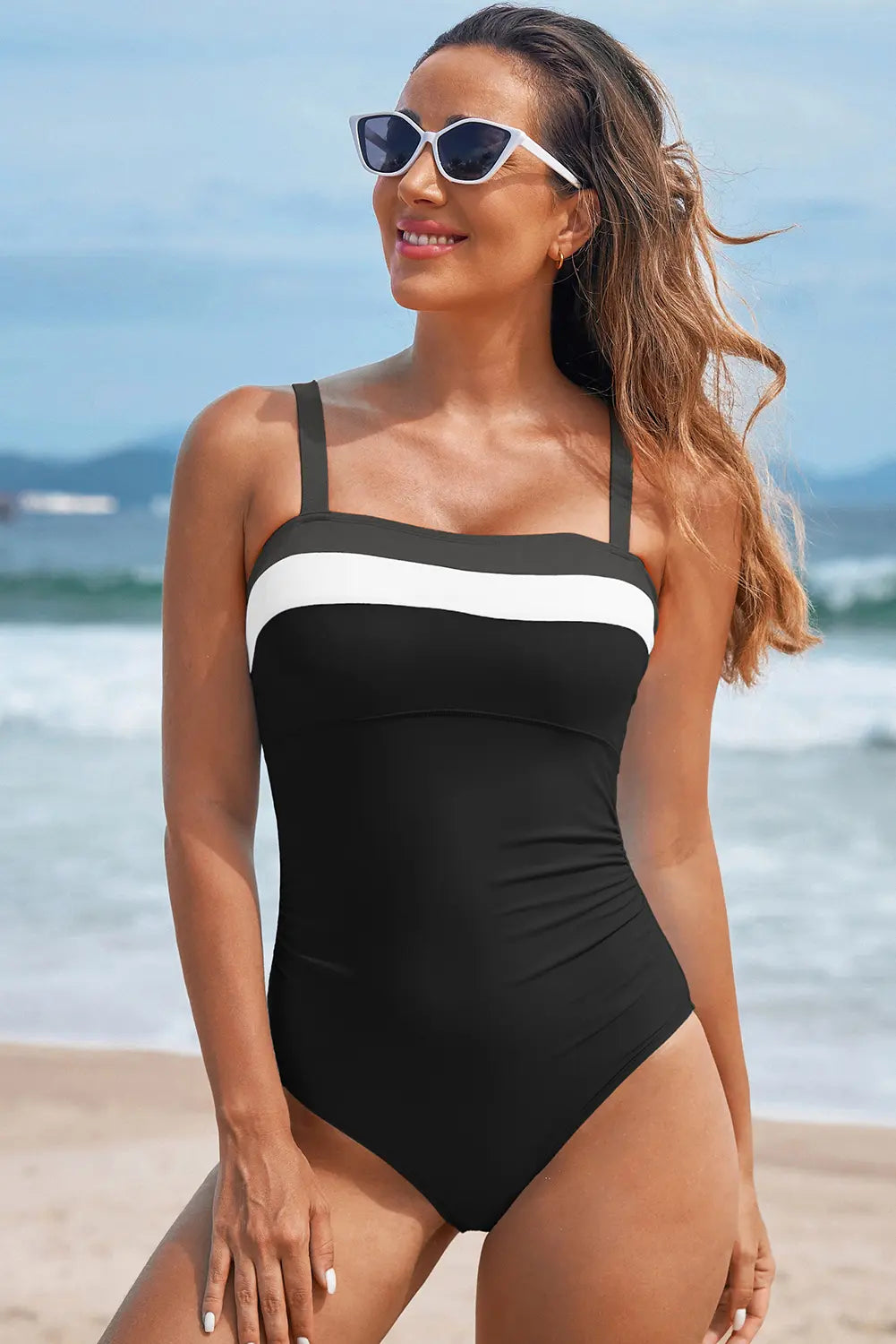 Woman wearing a black and white swimsuit on a beach