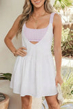 Woman wearing a white dress over a purple checkered top outdoors.