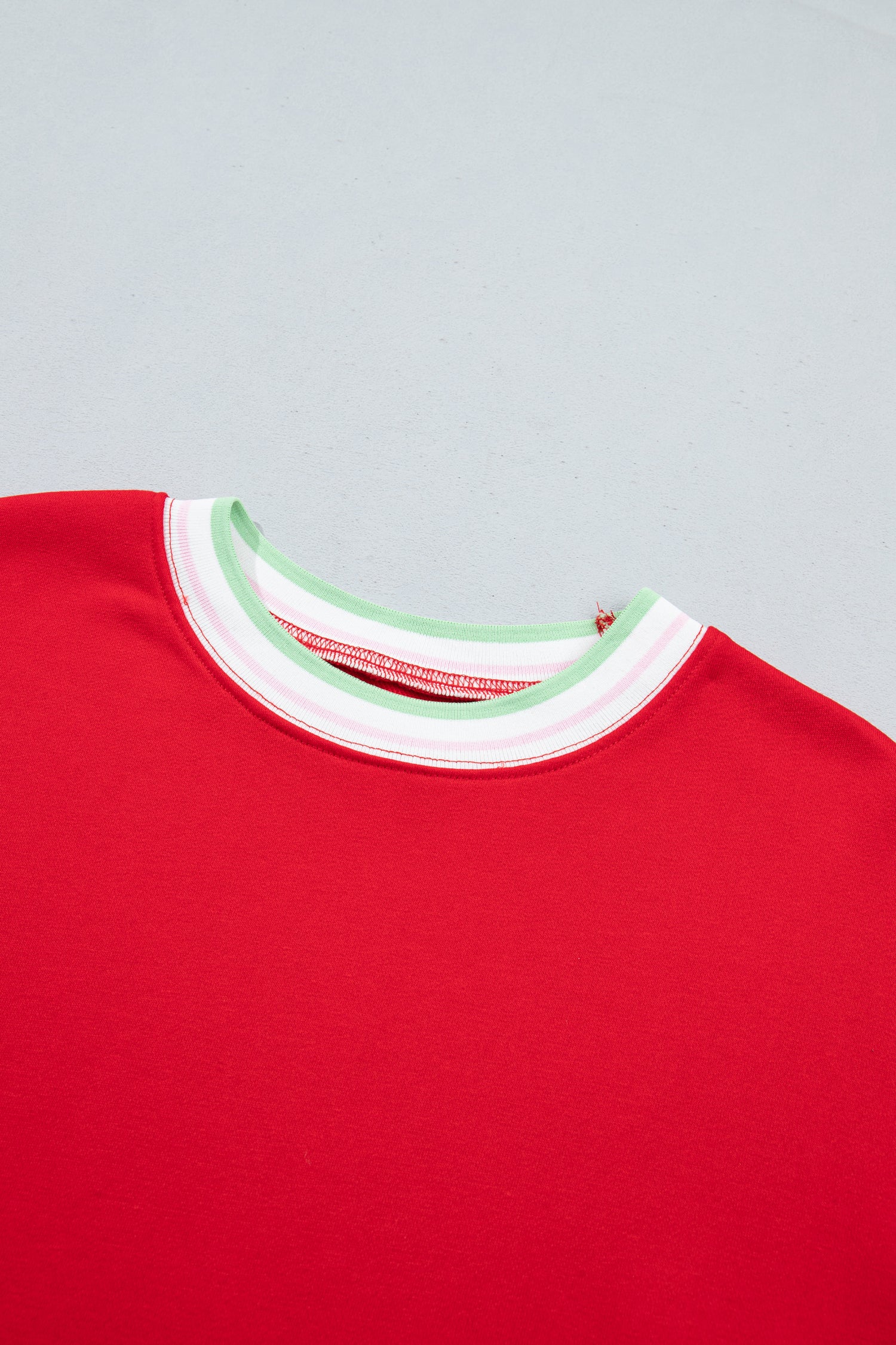 Close-up of a red crewneck sweatshirt showing the collar