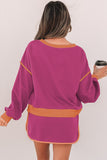 Woman wearing a purple dress with orange accents, holding a coffee cup.