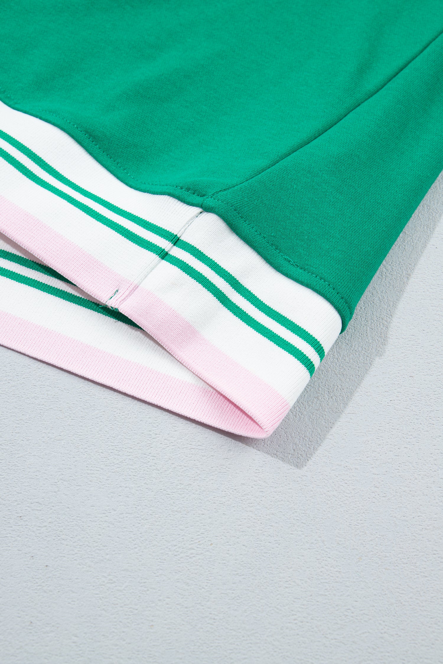 Close-up of a green garment corner with white and light pink striped