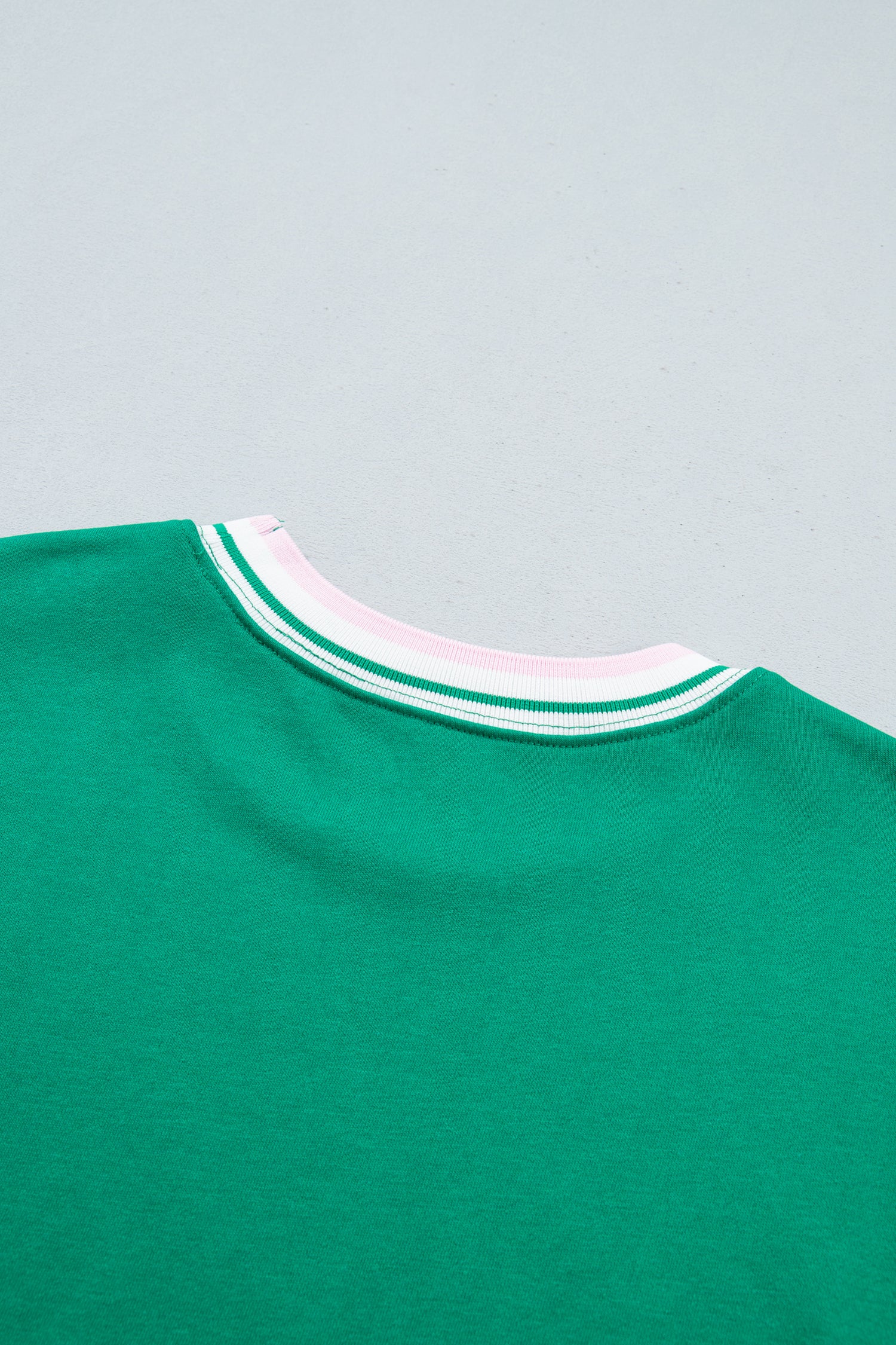 Close-up of the collar of a green crewneck sweatshirt