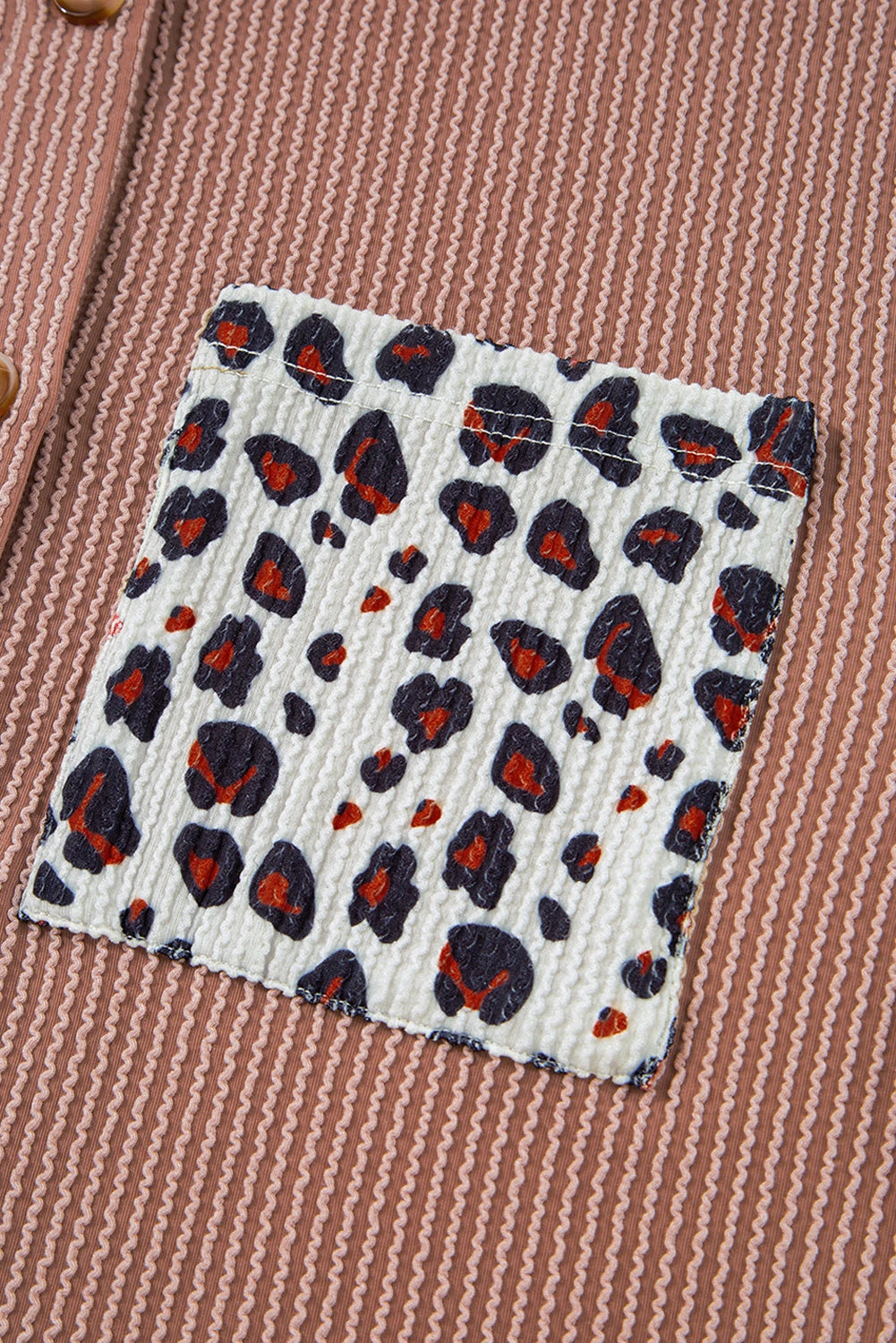 Fabric swatch with leopard print pattern on a textured fabric background.