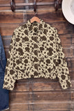 Cropped cow-print jacket in dark brown and beige with long sleeves and collar on wooden hanger.