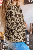 Woman wearing beige and brown cow-print jacket with blue jeans, shown from a side-back view in a store.