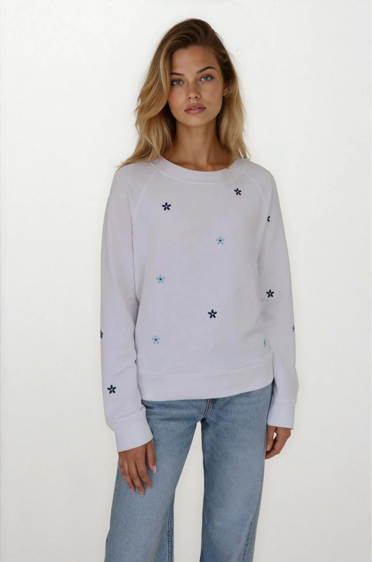 Woman wearing a light gray sweater with star patterns on a white background