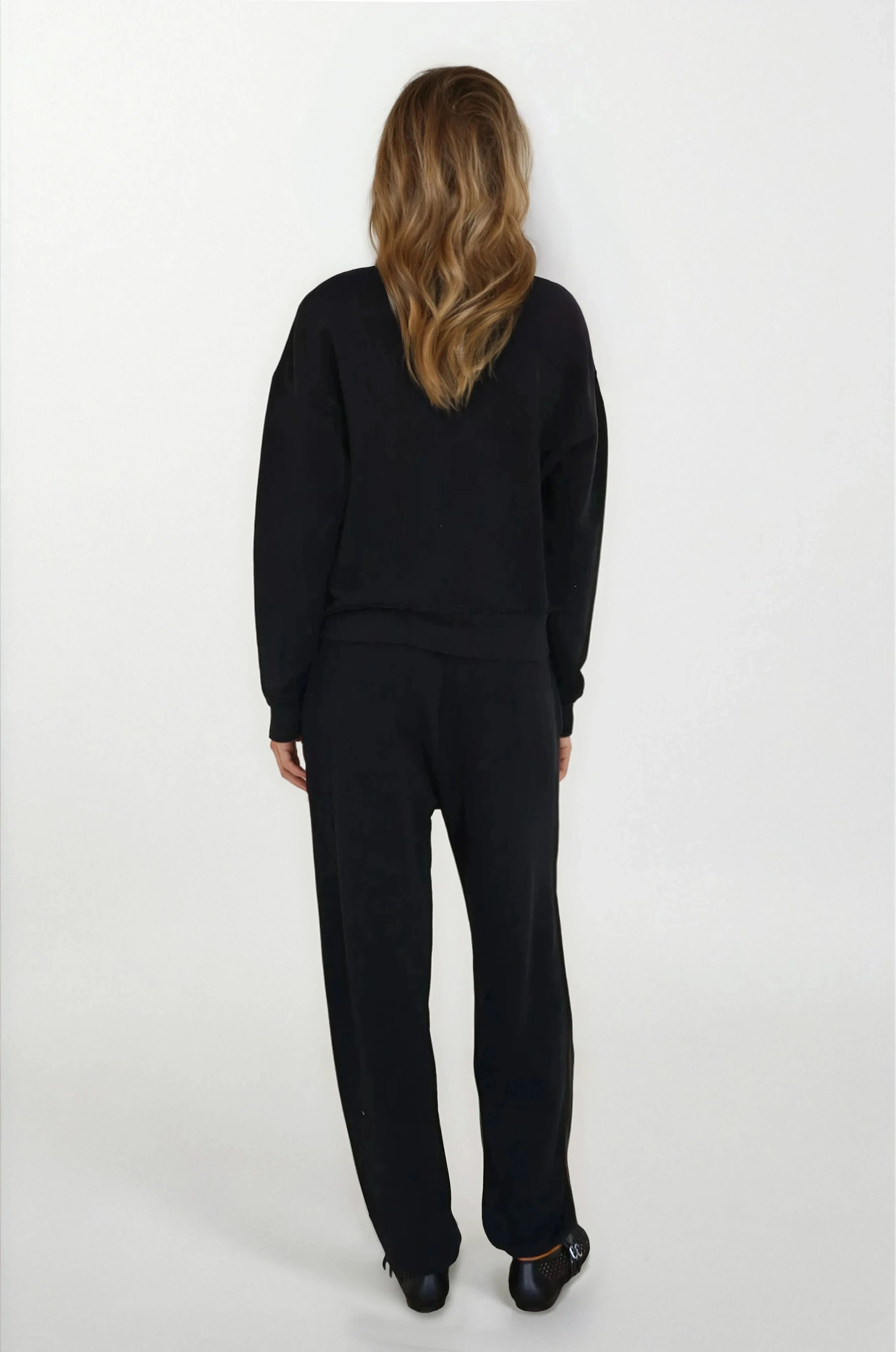 Person wearing a black outfit on a white background
