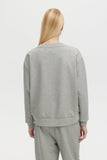 Person wearing a gray sweatshirt and pants on a white background