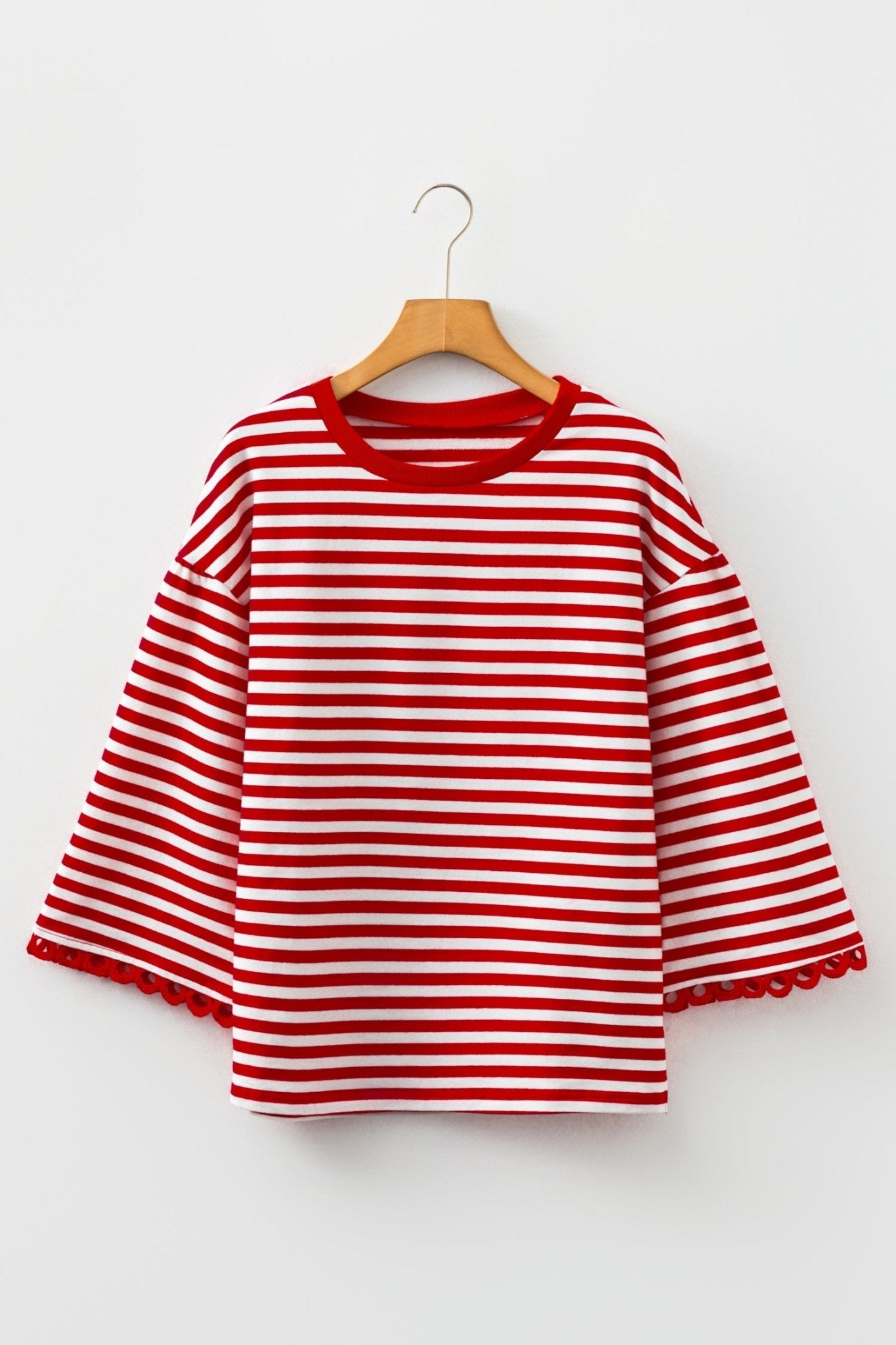 Red and white striped shirt on a hanger against a white background