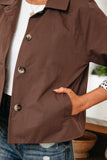 Brown short-sleeve shirt with buttons worn by a person, indoors.