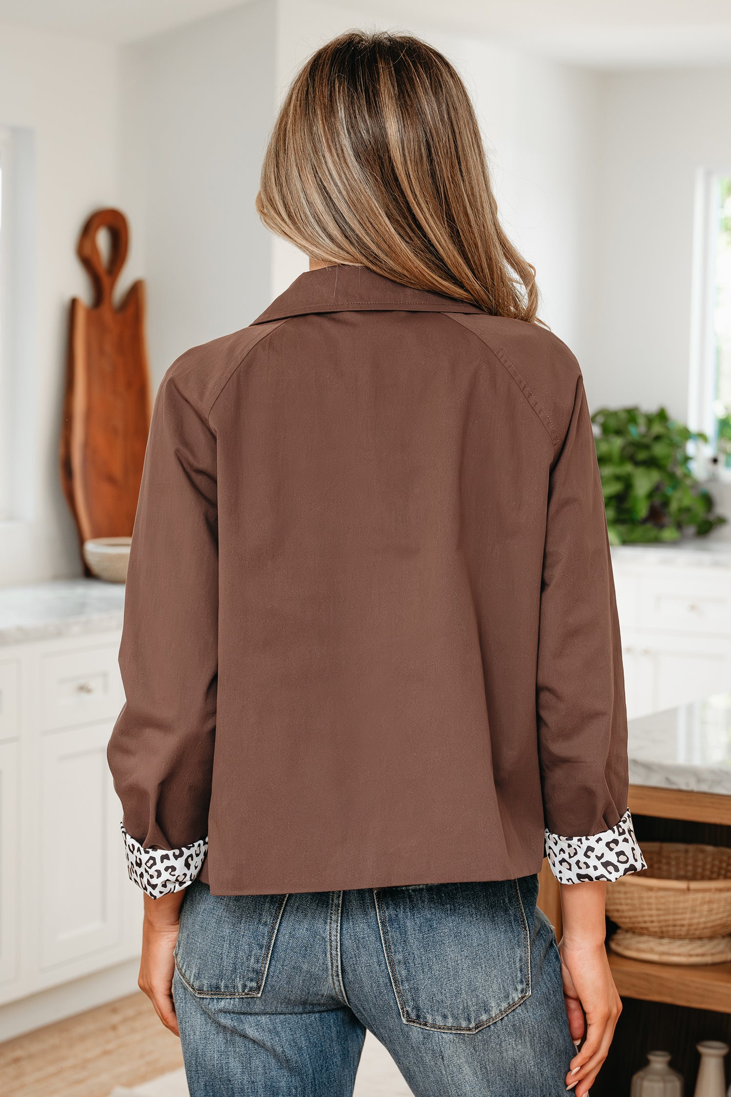 Person wearing a brown jacket in a kitchen setting