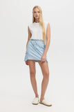 Woman wearing a light blue skirt and white top on a white background