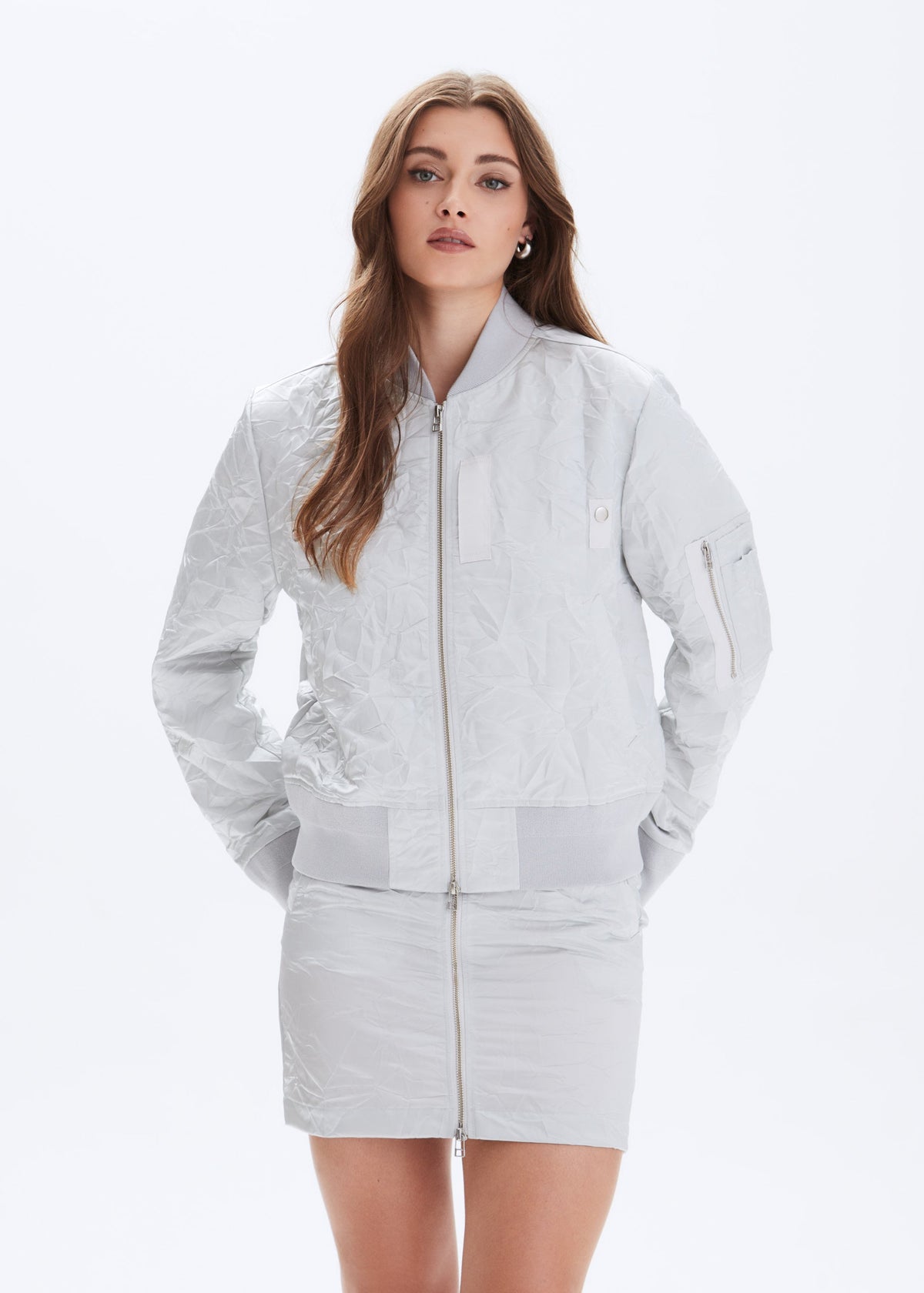 Woman wearing a light gray jacket and skirt set on a white background