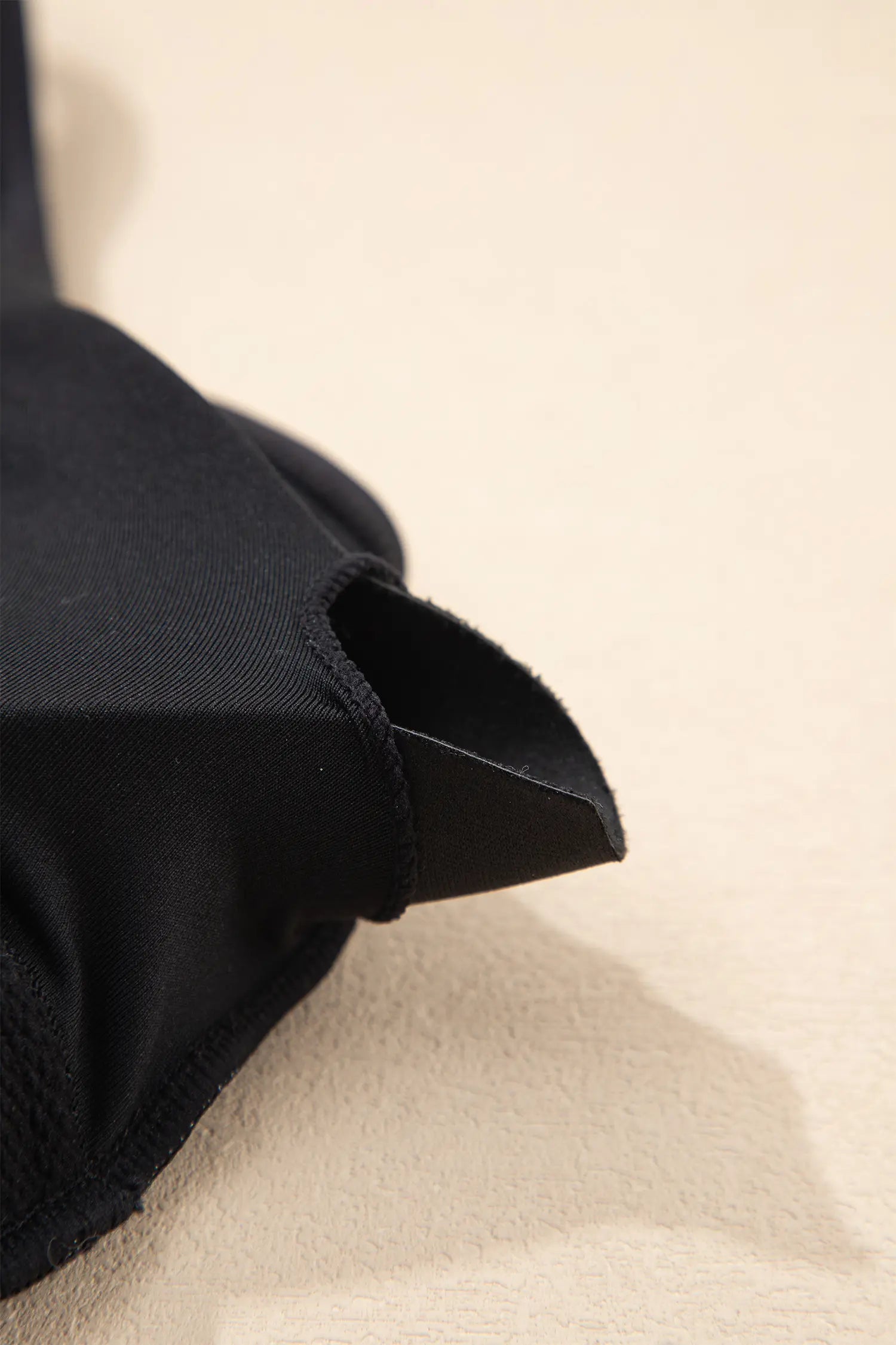Close-up of black fabric on a beige background