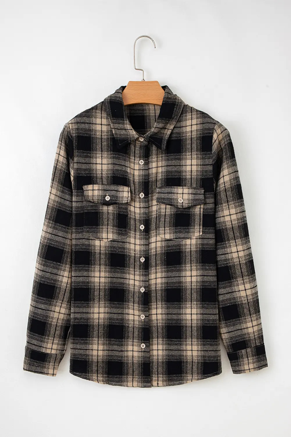 Plaid shirt on a hanger against a white background