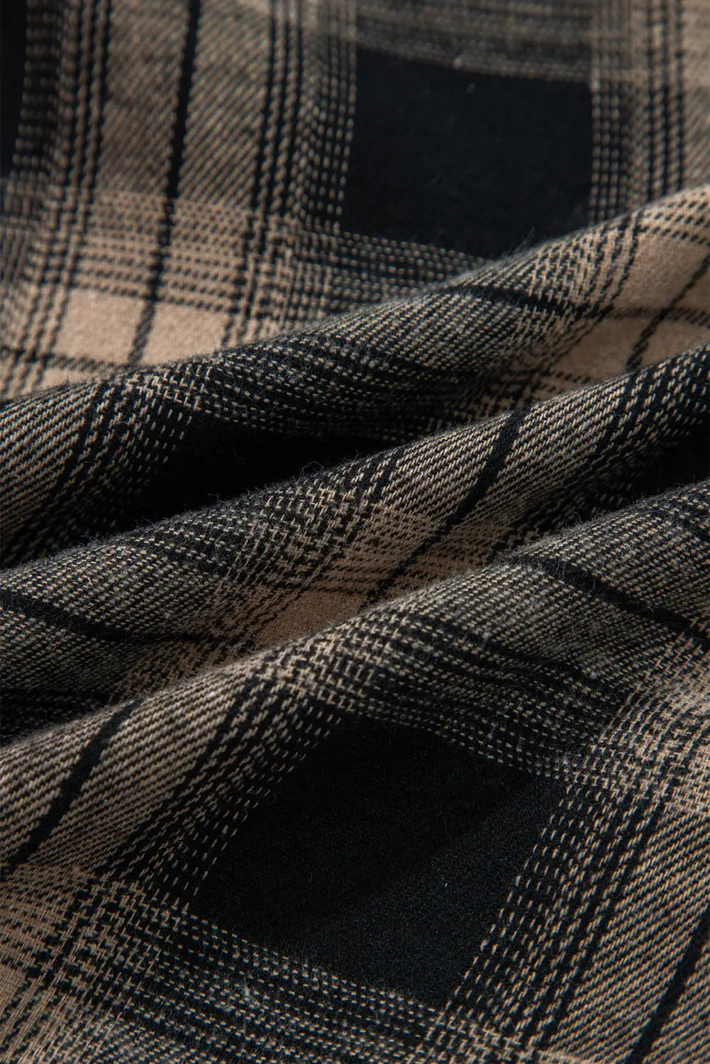Close-up of plaid fabric with black and beige pattern