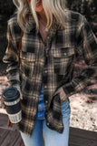 Person wearing a plaid shirt holding a coffee cup outdoors