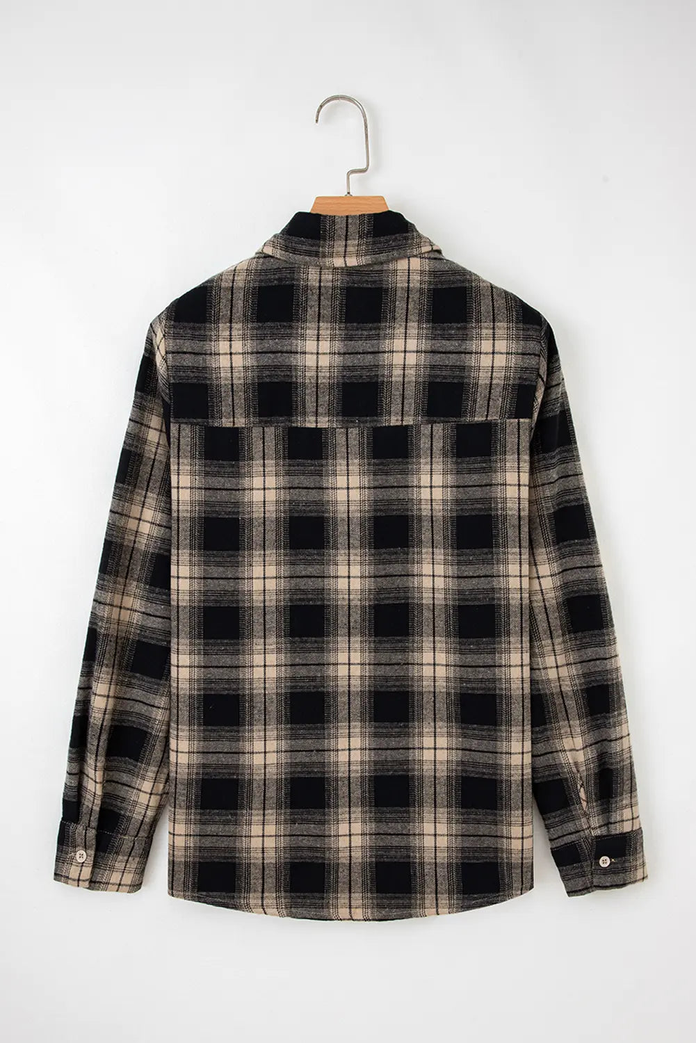 Plaid shirt on a hanger against a white background
